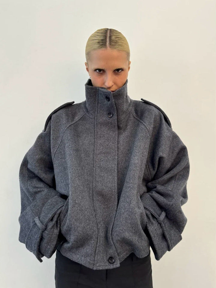 Ladies short cut oversized wool jacket with high stand-up collar, shoulder flaps and adjustable sleeve straps
