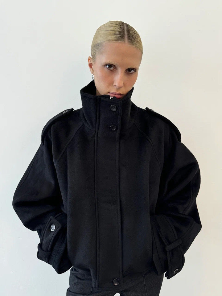 Ladies short cut oversized wool jacket with high stand-up collar, shoulder flaps and adjustable sleeve straps