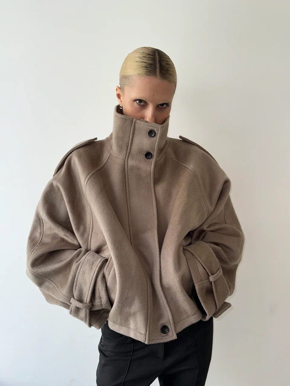 Ladies short cut oversized wool jacket with high stand-up collar, shoulder flaps and adjustable sleeve straps